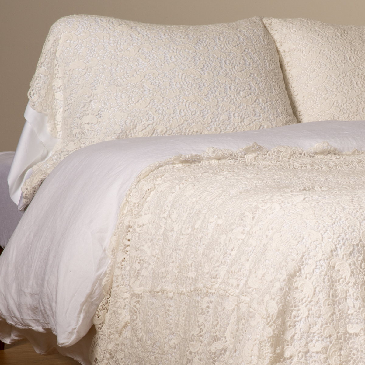 Bella Notte Allora Lace coverlet and pillowcase in Winter White, styled on a made bed.