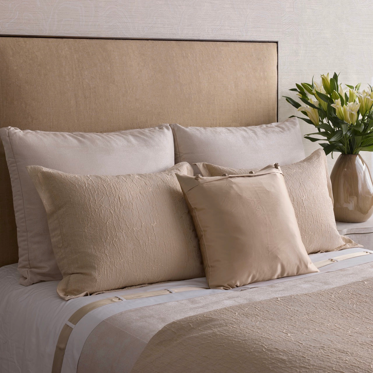 Ann Gish Allure duvet set in champagne, styled bed with layered Euro and square pillows.