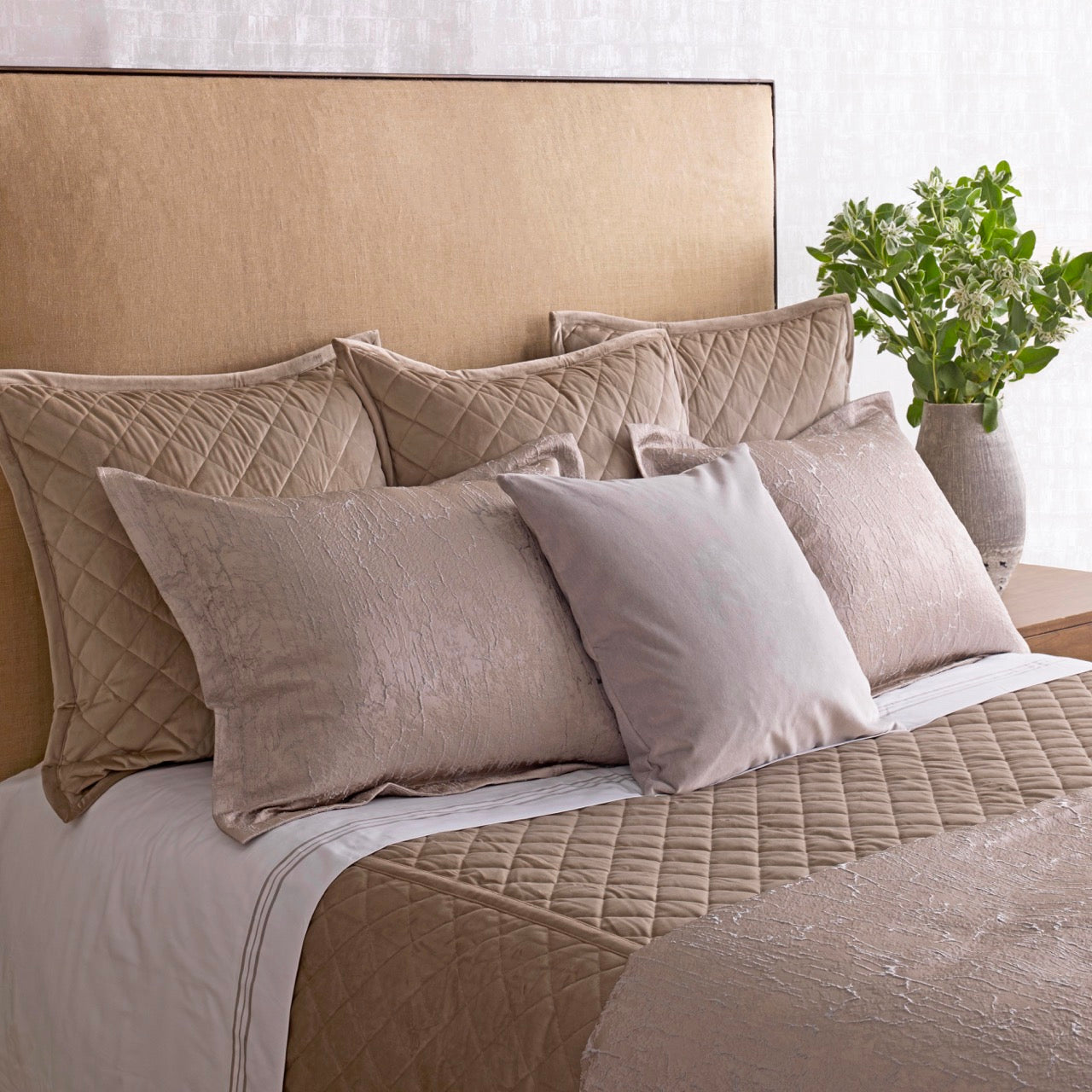 Ann Gish Allure duvet set styled on bed with quilted shams and velvet pillows in champagne tones.