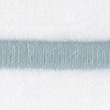 Close-up of pale blue fringe trim detail on white linen fabric.
