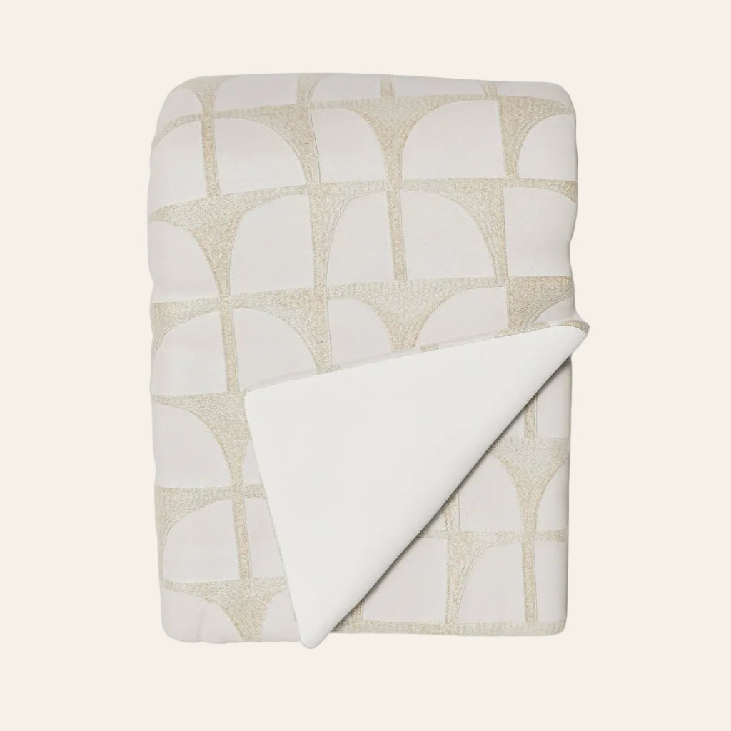 Ann Gish Arches throw in ivory and champagne arch pattern, folded with plain white reverse visible.