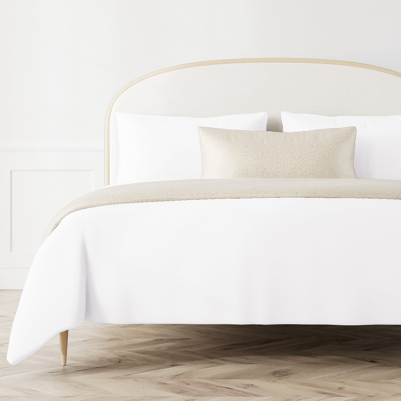 Ann Gish Array bed finisher set in champagne, draped across white bedding in a styled bedroom.