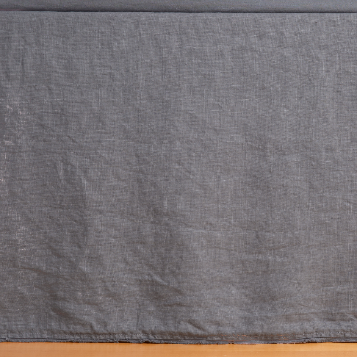 Bella Notte Austin bed skirt in French Lavender, close-up of gathered linen fabric draping to floor.