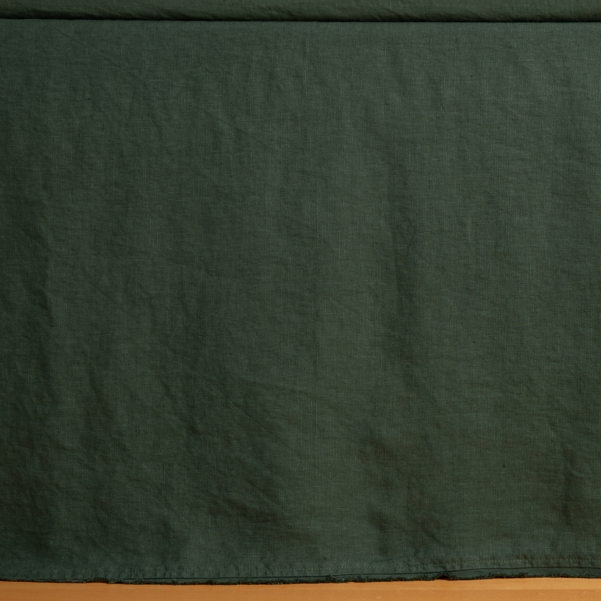 Bella Notte Austin bed skirt in Juniper, close-up showing washed linen texture and drape.