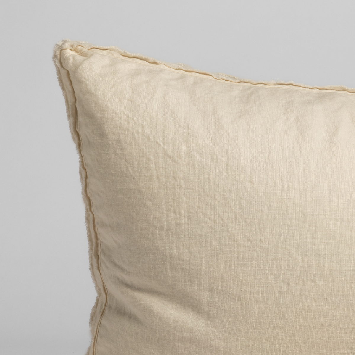 Close-up of Natural linen sham corner showing relaxed texture and whipstitch edge detail.