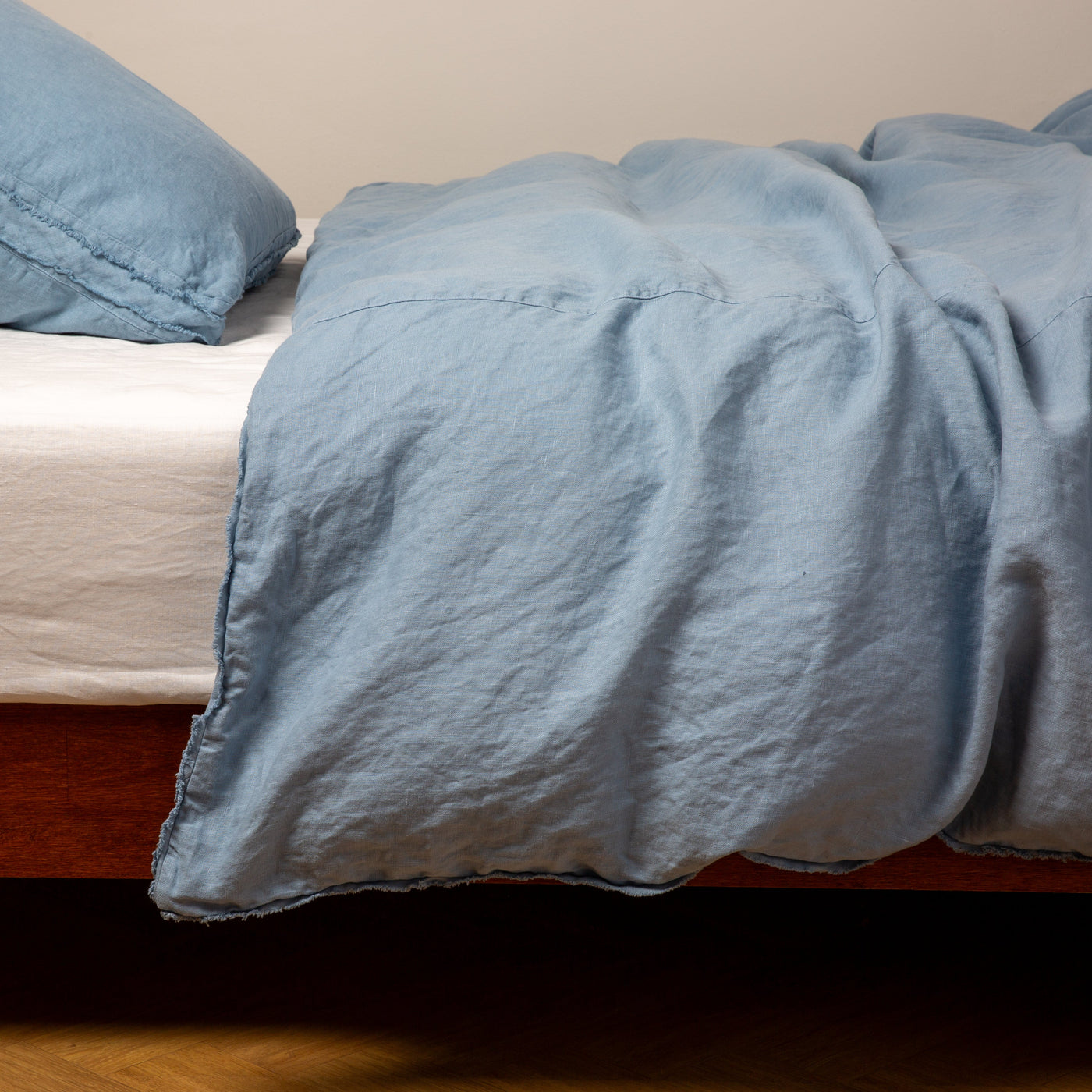 Bella Notte Austin duvet cover in Tahoe Blue, draped loosely over a bed, showing relaxed linen texture.