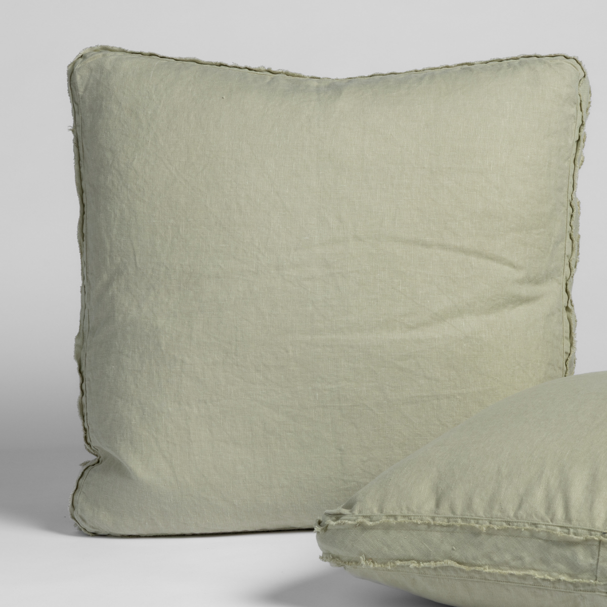 Desert Sage linen sham with frayed edge trim, shown front-on and angled side view.