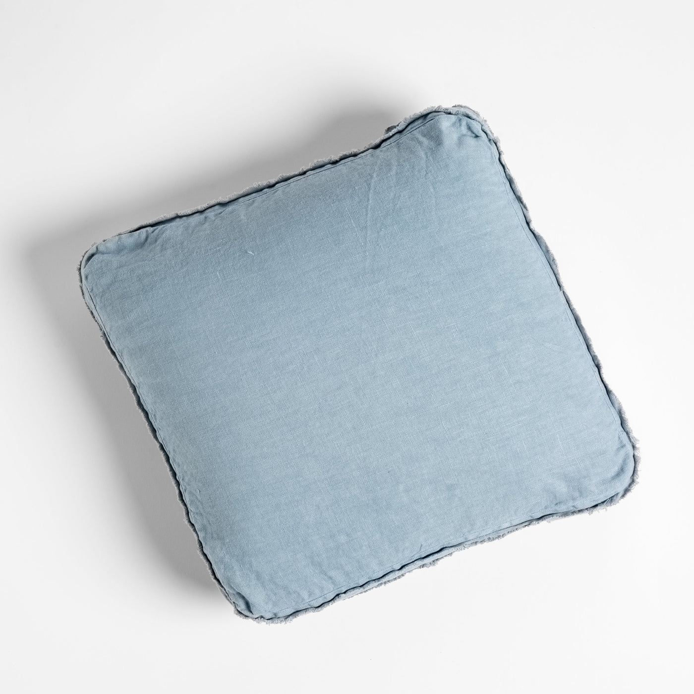 Bella Notte Austin throw pillow in Tahoe Blue, overhead view showing frayed linen edge detail.