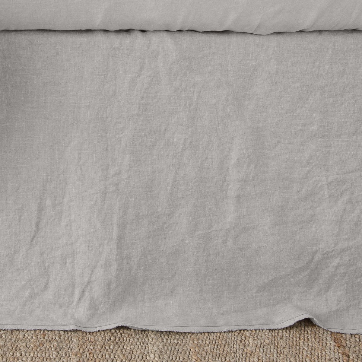 Close-up of Bella Notte Austin bed skirt in Fog, showing relaxed linen drape and scalloped hem.