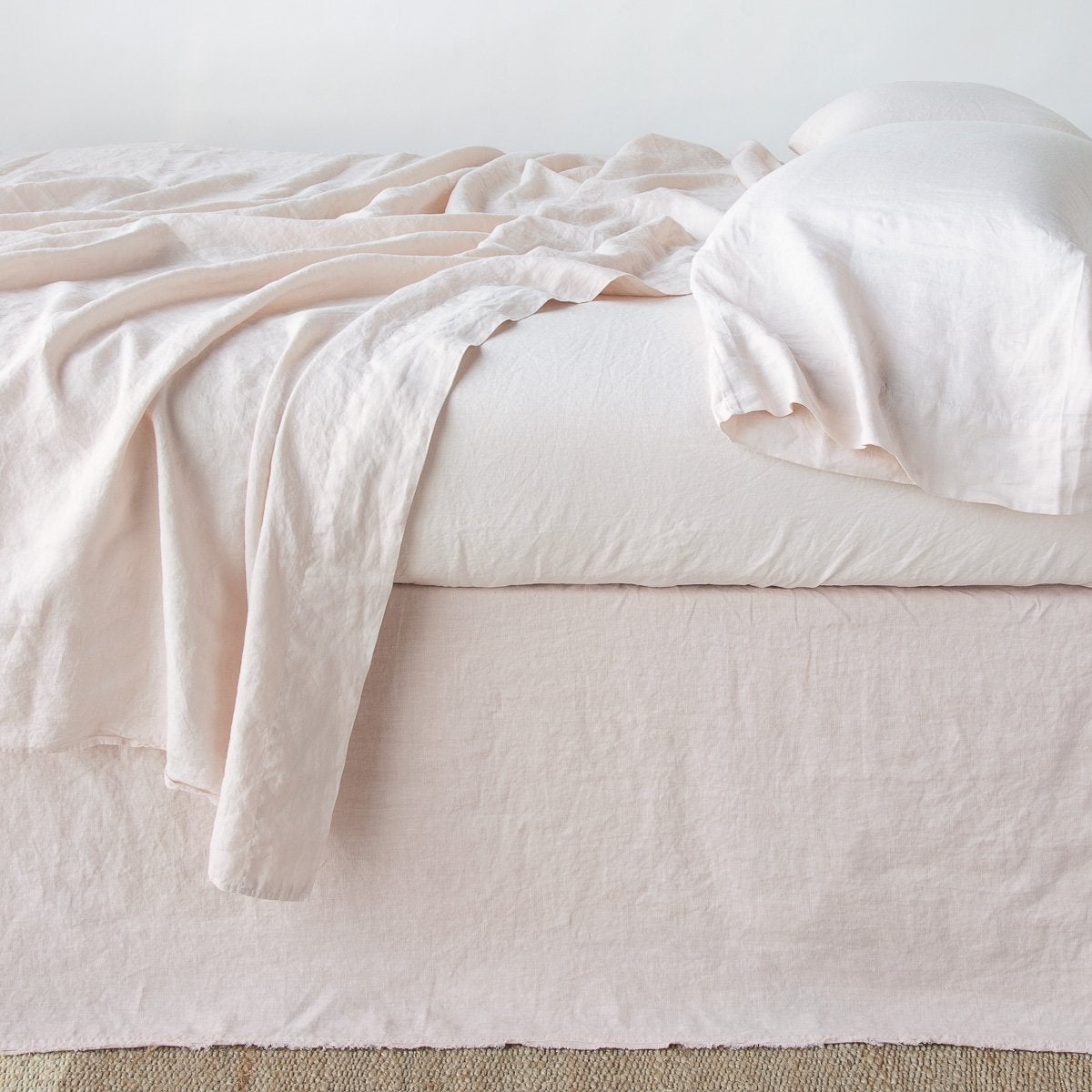 Bed skirt in Pearl with softly gathered linen drape, styled on a made bed with matching linens.
