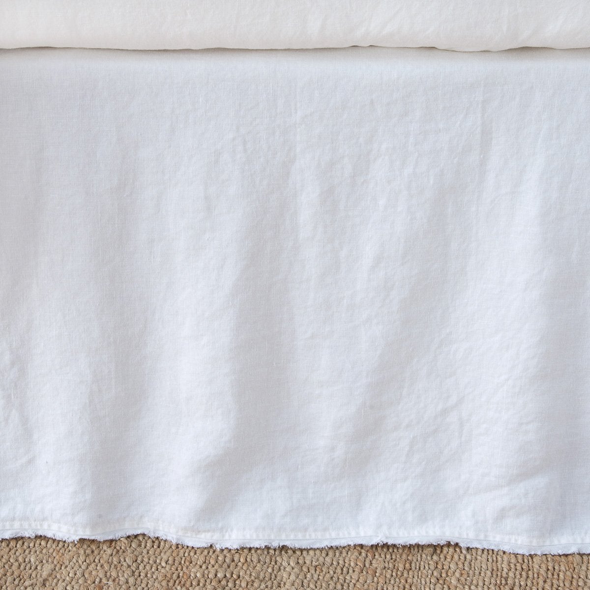 Bella Notte Austin bed skirt in White, showing full linen drop with natural texture.