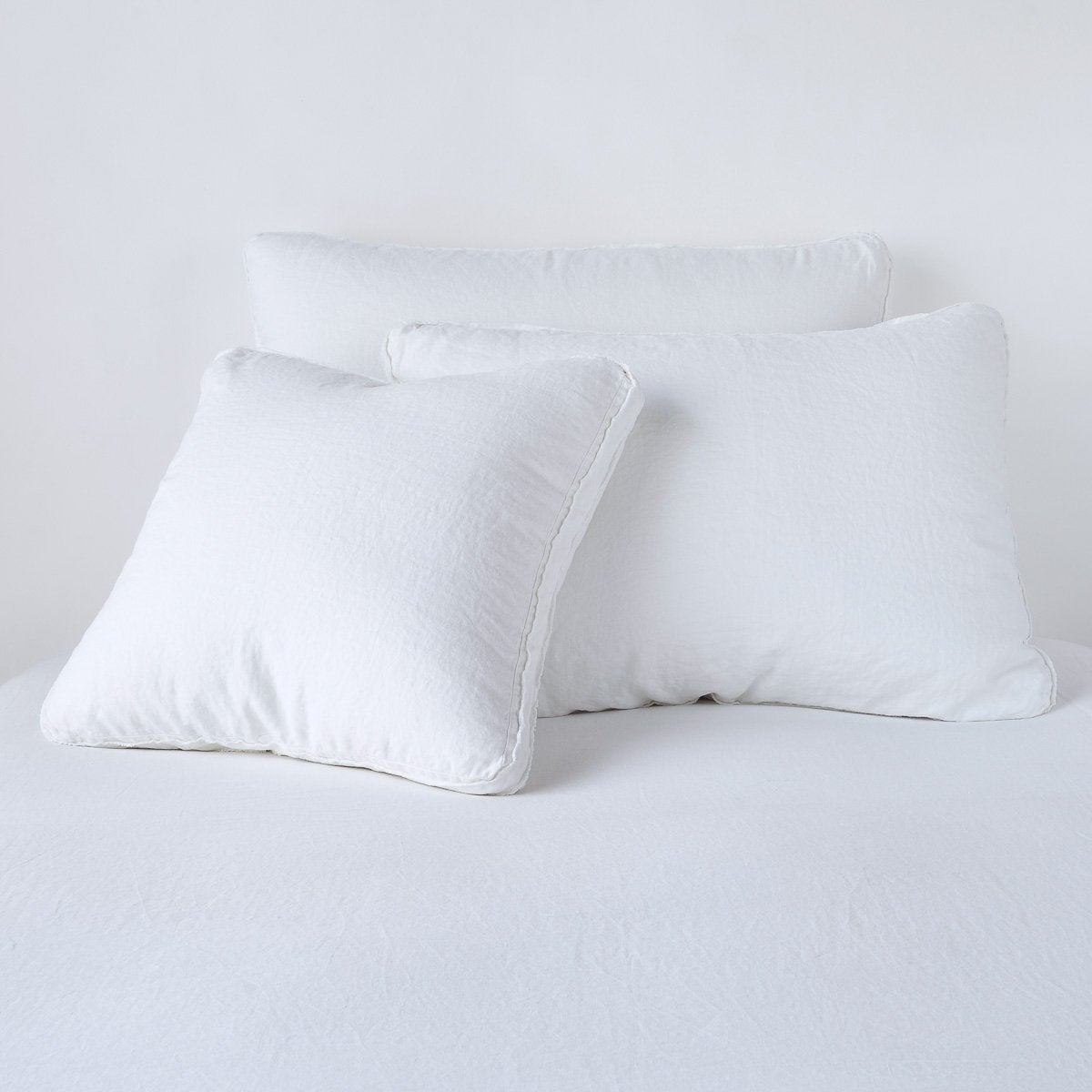 Bella Notte Austin sham in White, three sizes stacked on a white linen bed.