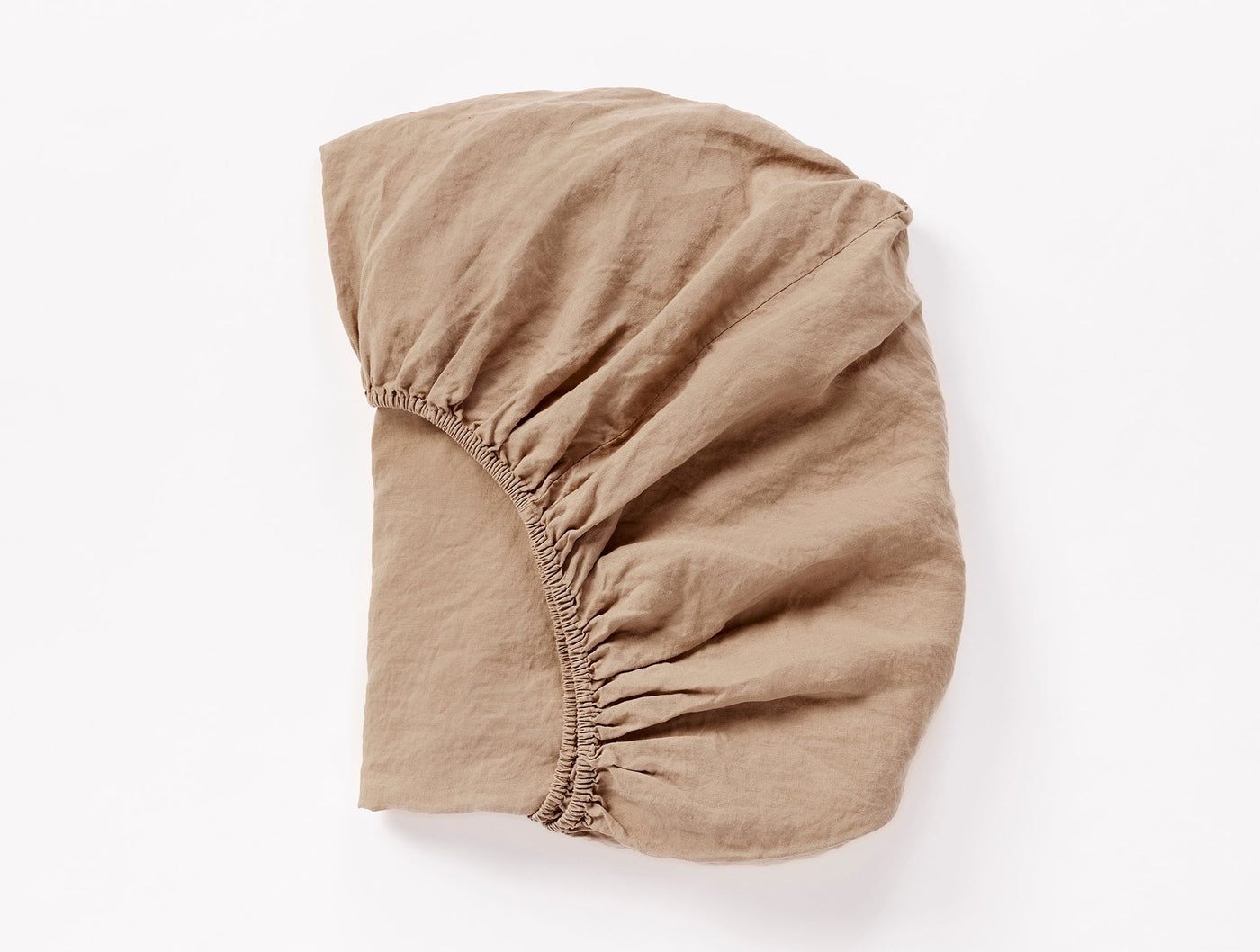 Coyuchi Relaxed Linen fitted sheet in tan, shown flat with elasticated corners visible.