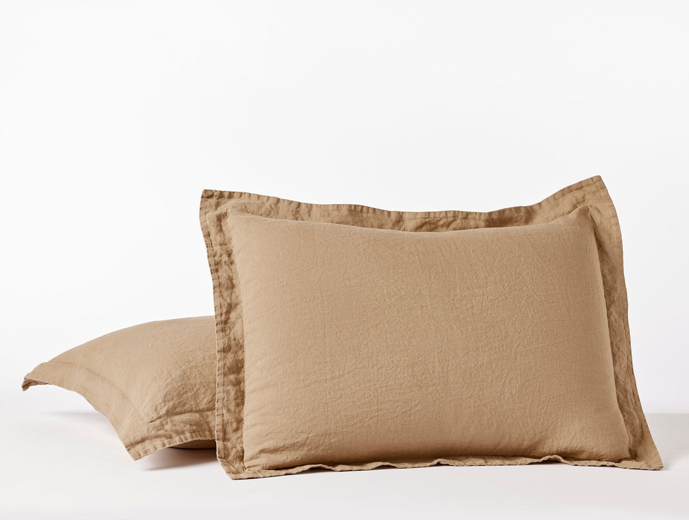 Pair of Coyuchi Relaxed Linen shams in camel, showing flanged edges and soft washed texture.