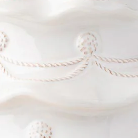 Close-up of ivory ceramic cookie jar with embossed rope swag and dotted relief detail.