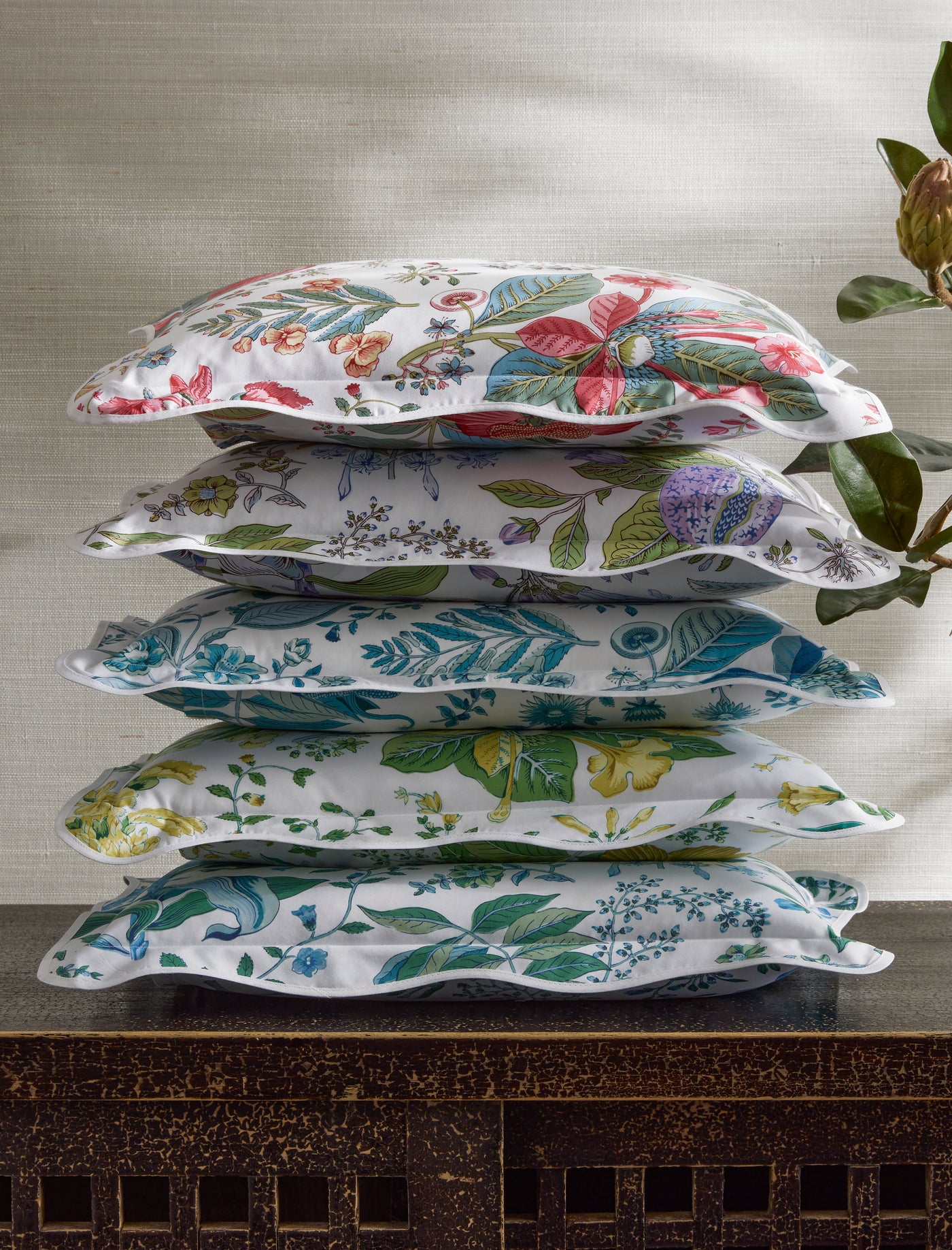 Five Matouk Pomegranate scallop-edged shams stacked, each in a different botanical colorway.