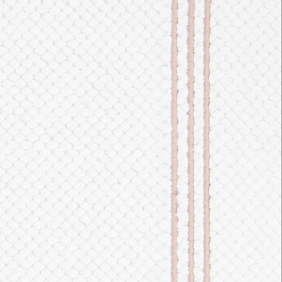 Close-up of white waffle-weave texture with dual blush embroidered stripes.