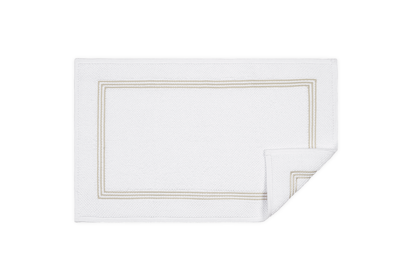 Corner fold detail of Matouk Bel Tempo bath rug in white with champagne triple-stripe border.