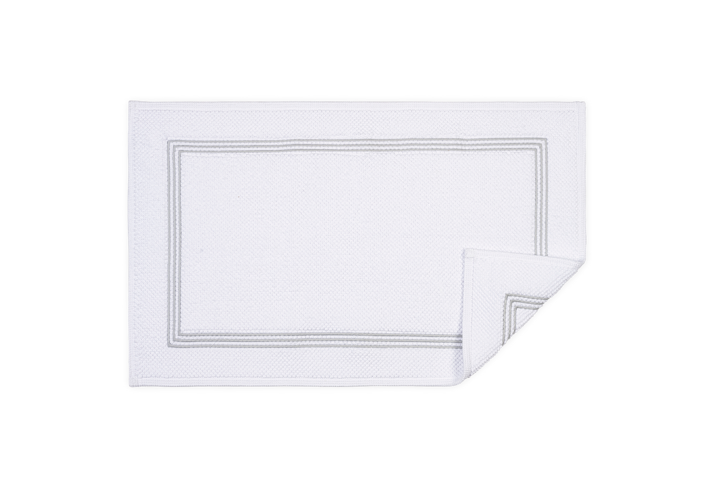 Corner detail of white Matouk Bel Tempo bath rug with grey triple-stripe embroidered border.