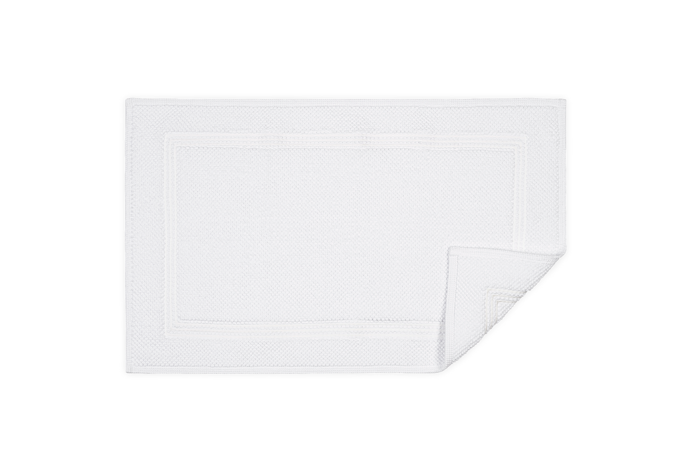 Corner detail of white Matouk Bel Tempo bath rug showing folded edge and double-border trim.