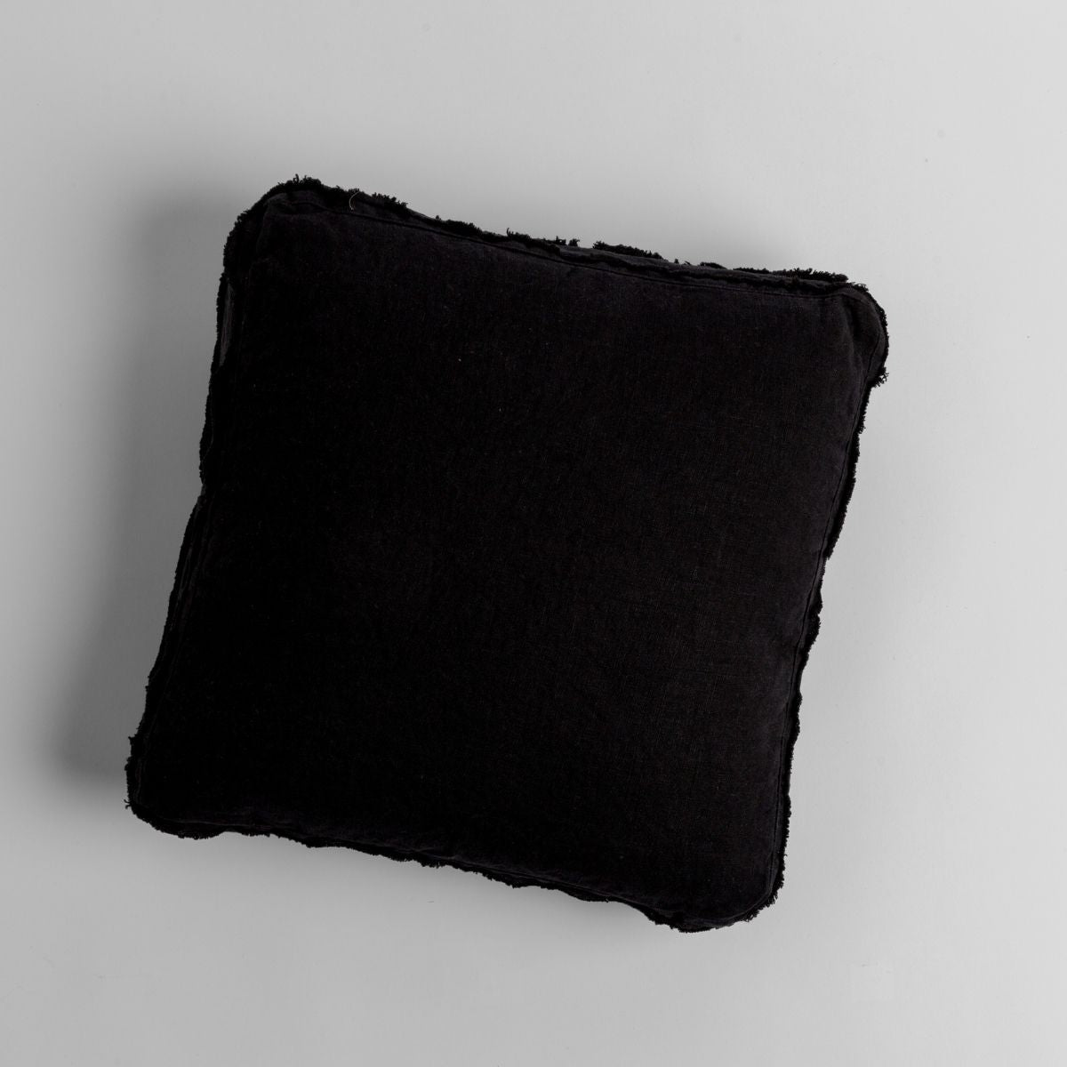 Corvino Austin throw pillow, plush black faux fur texture, overhead view on grey ground.