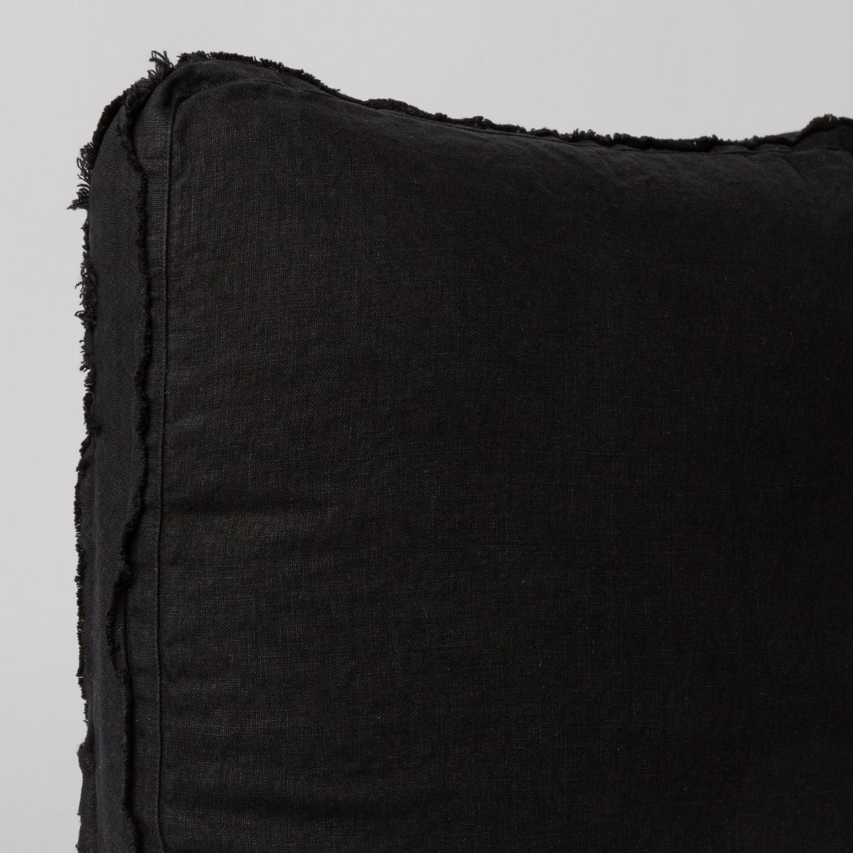 Close-up of Corvino Austin throw pillow corner showing frayed linen edge detail.