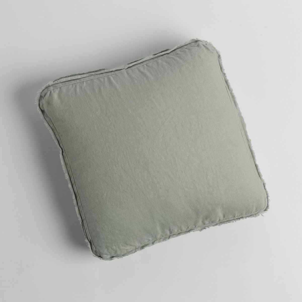 Eucalyptus linen throw pillow with soft fringe trim, shown flat on white surface.
