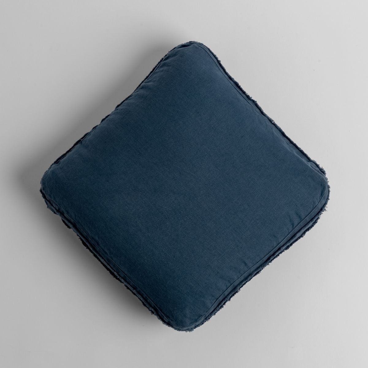 Austin throw pillow in Midnight linen, overhead view showing frayed edge trim detail.
