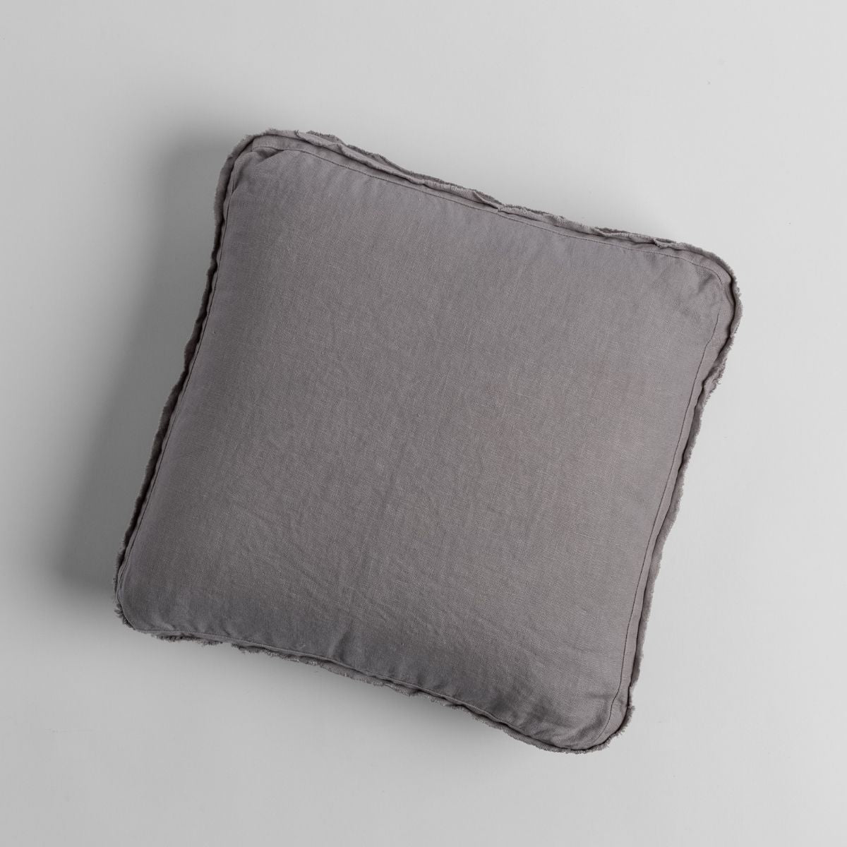 Overhead view of Bella Notte Austin throw pillow with ruffled edge in medium grey linen.