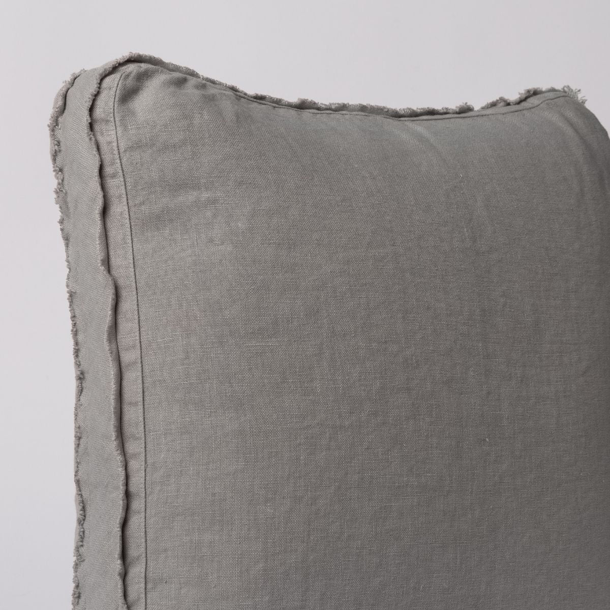 Close-up of Bella Notte Austin throw pillow corner showing frayed linen edge trim detail.