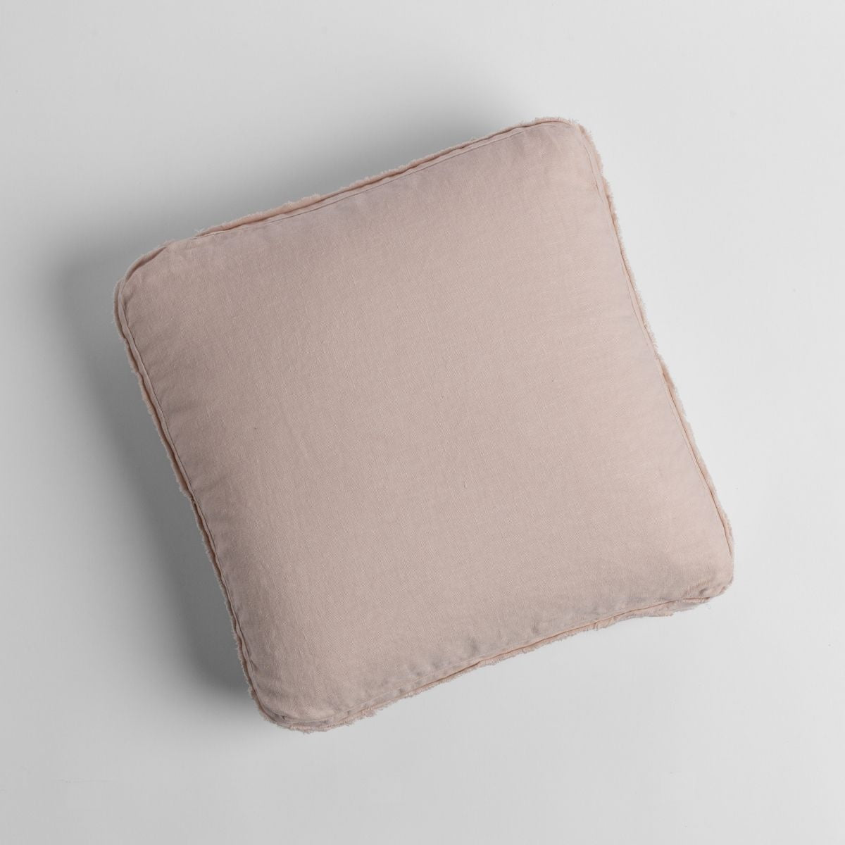 Bella Notte Austin throw pillow in Pearl, shown from above on a light grey surface.