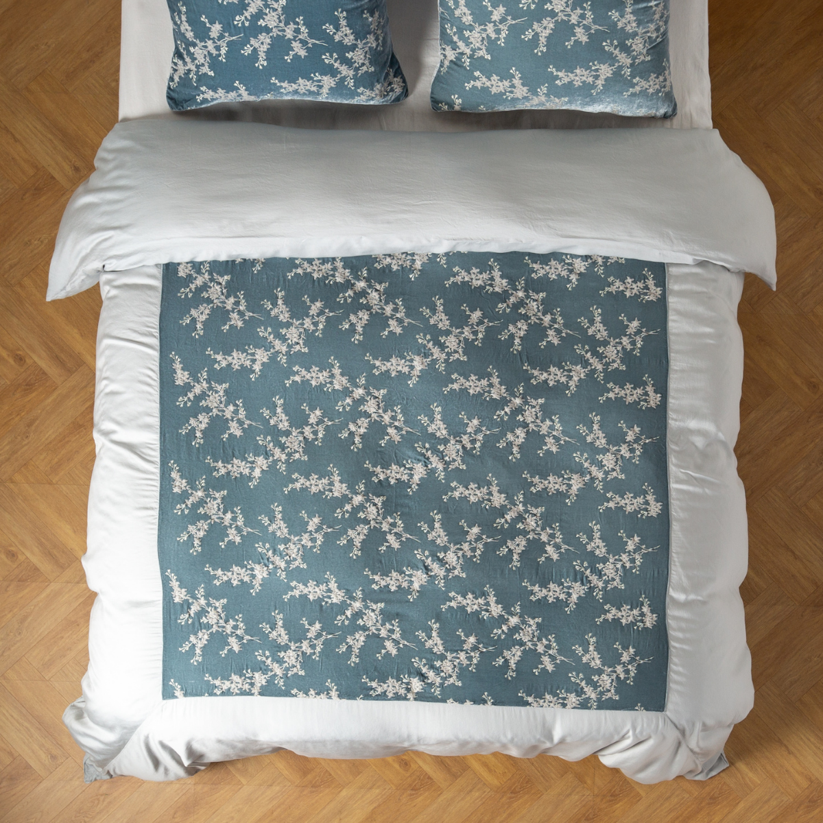 Overhead view of Cloud Lynette Luxe duvet cover with floral branch print, styled on a bed with matching pillows.