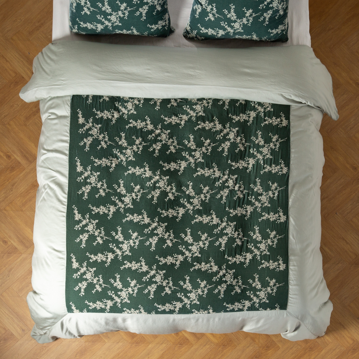 Overhead view of Eucalyptus duvet with floral sprig panel and matching pillowcases on styled bed.