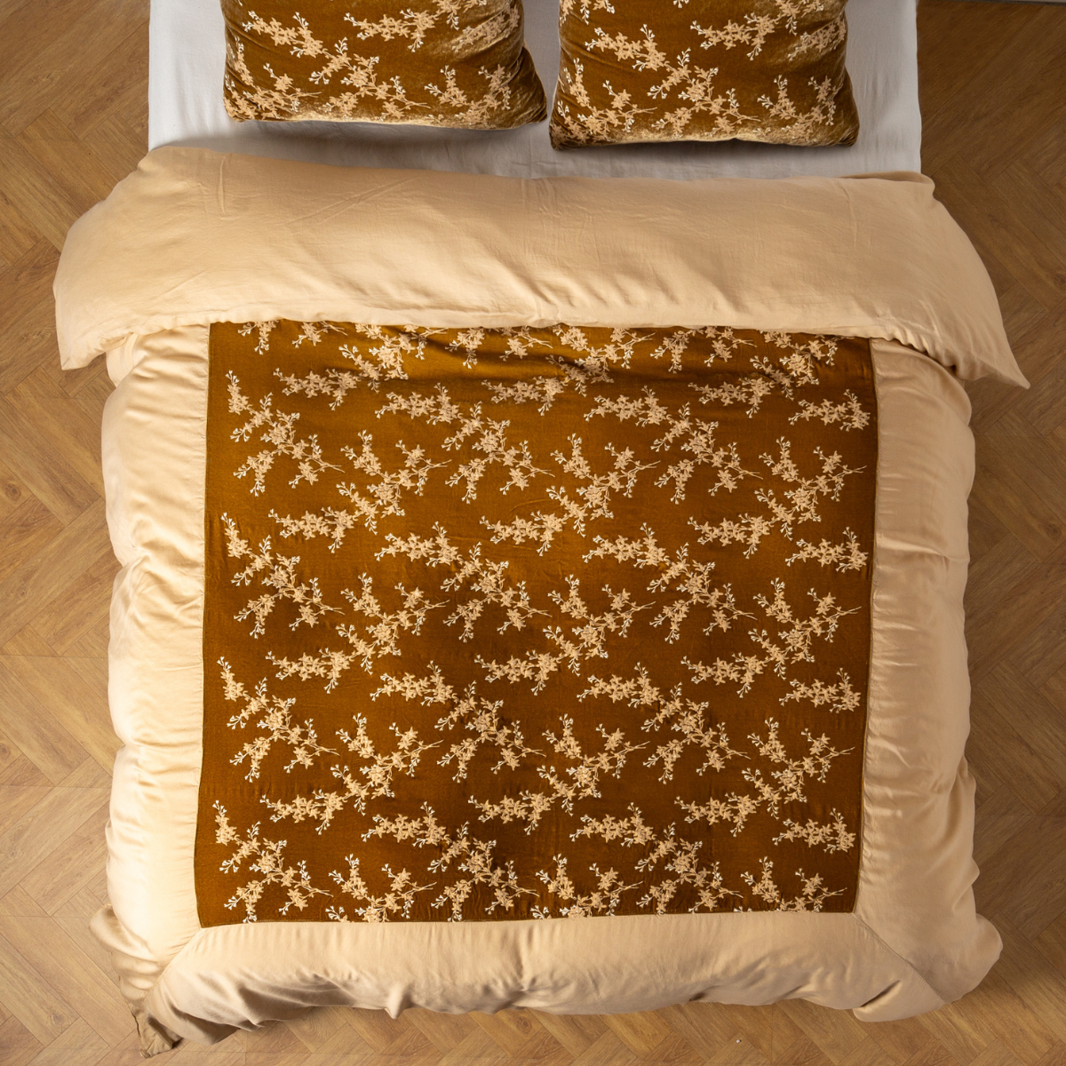 Overhead view of Honeycomb duvet cover with floral vine pattern draped across a styled bed.