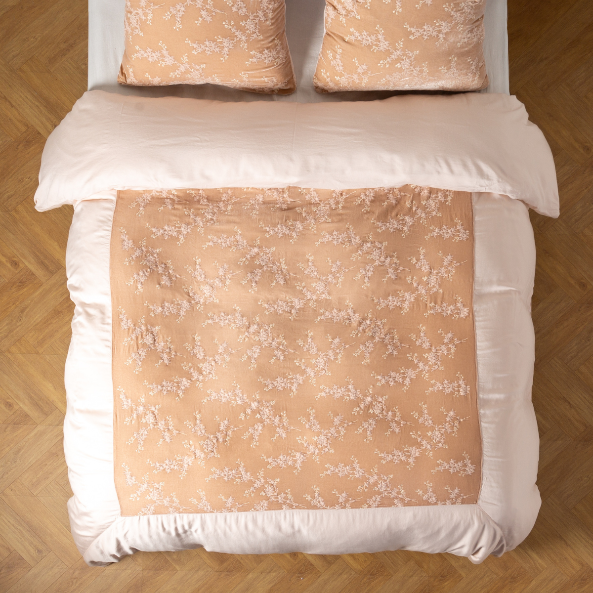 Overhead view of Pearl Lynette Luxe duvet cover with floral pattern, styled on bed with matching shams.