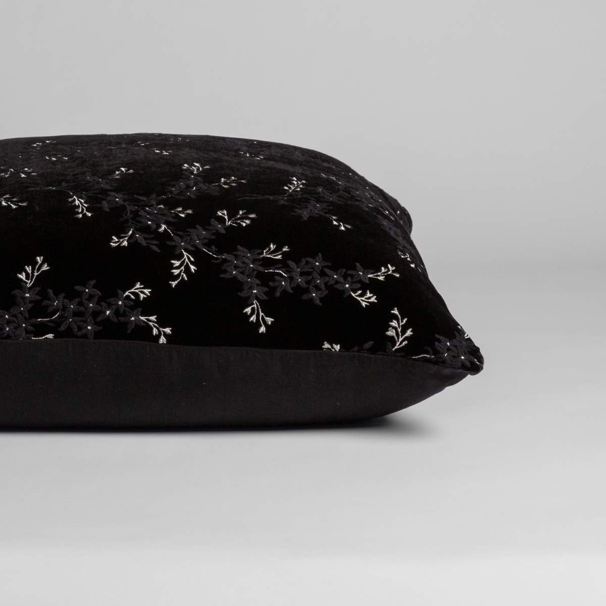 Side profile view of Bella Notte Lynette Luxe sham in Corvino with white floral embroidery on velvet.