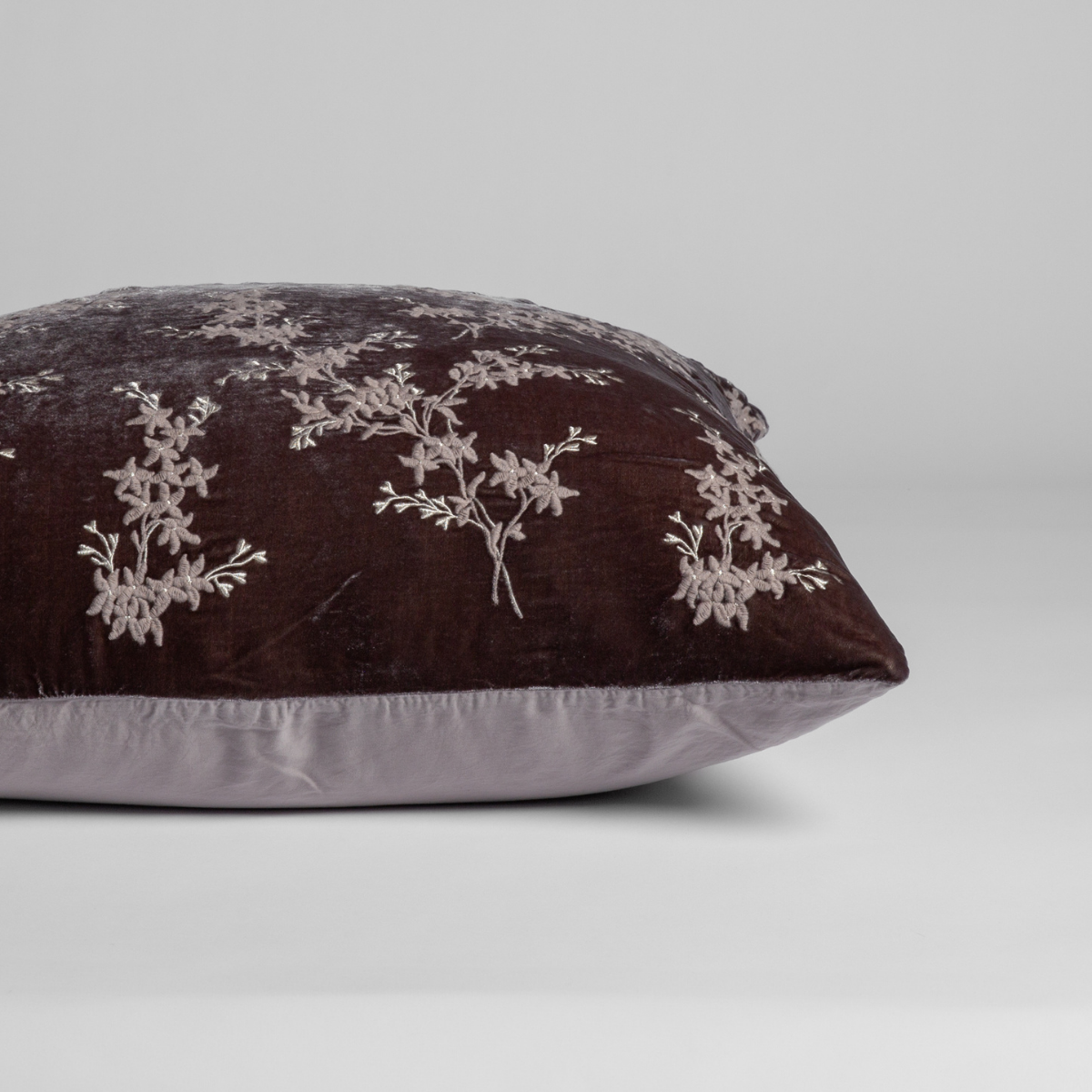 Side profile close-up of Bella Notte Lynette Luxe sham in Fog, showing floral embroidery on dark velvet with pale reverse.