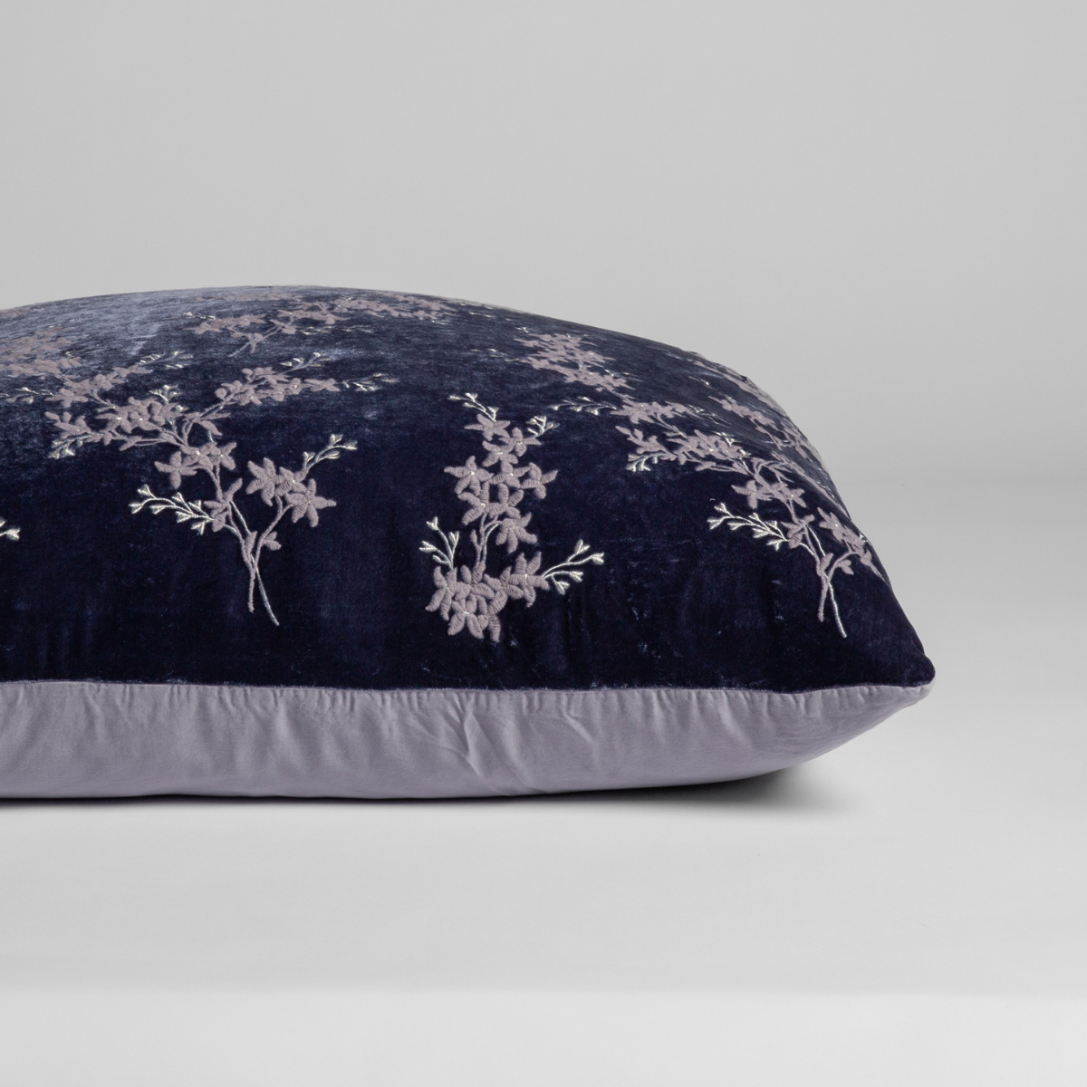 Side profile of Bella Notte Lynette Luxe sham in French Lavender, showing floral embroidery on navy velvet.