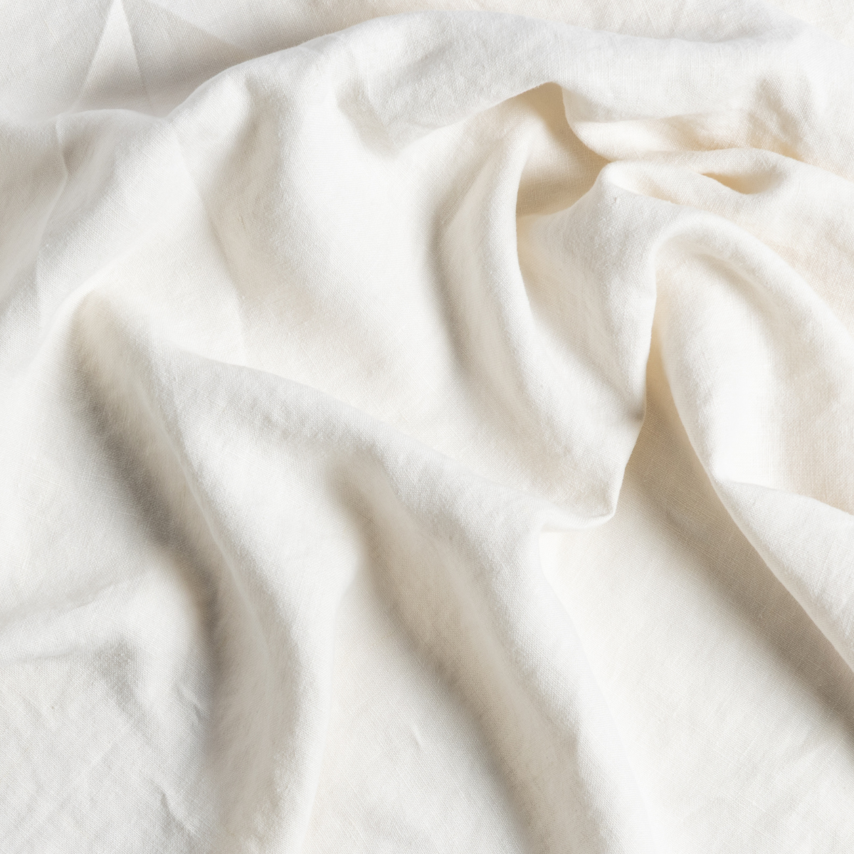 Close-up of Bella Notte Austin bed skirt in Natural, showing soft linen drape and texture.