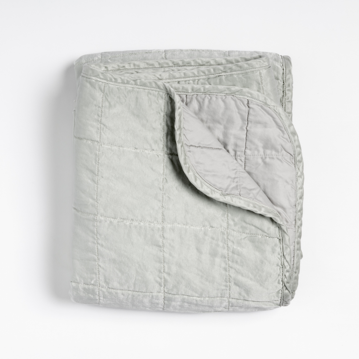 Corner fold detail of Bella Notte Sel blanket in Cloud, showing quilted texture and soft drape.