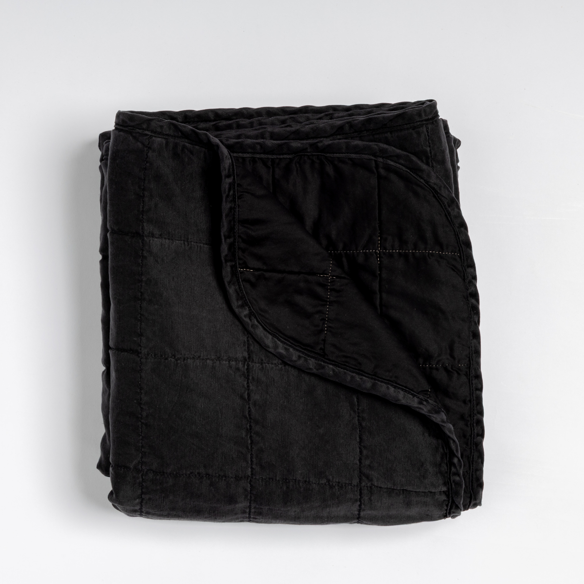 Folded Corvino Bella Notte Sel blanket showing quilted texture and satin trim detail.