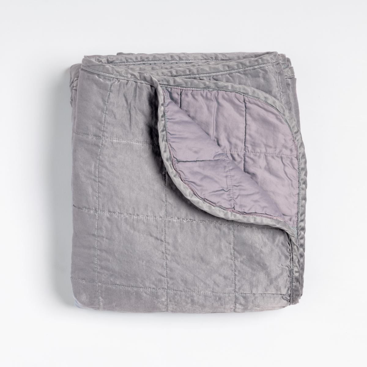 Corner fold detail revealing French Lavender lining on Bella Notte Sel quilted throw blanket.