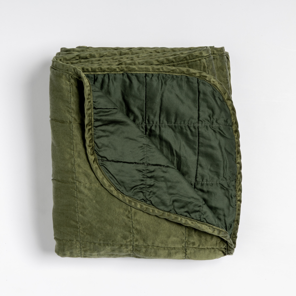 Folded Juniper quilted velvet throw, corner turned to reveal contrasting darker reverse.