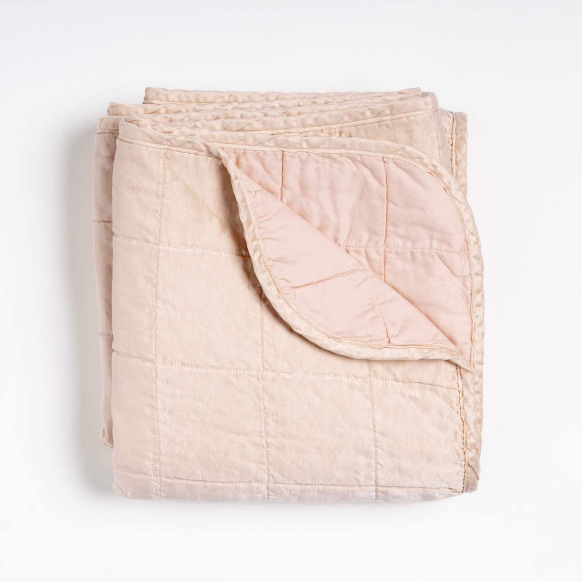 Corner fold detail of Bella Notte Sel blanket in Pearl, revealing satin-like lining.