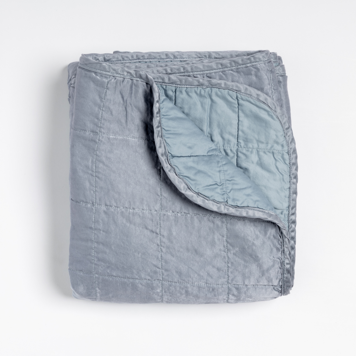 Folded Tahoe Blue Bella Notte Sel throw blanket with quilted stitching and corner turned back.