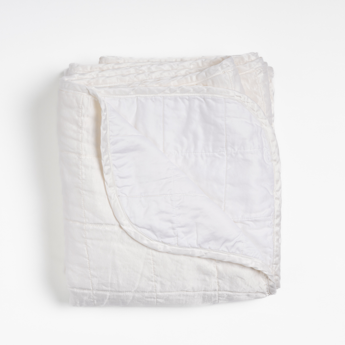Bella Notte Sel blanket in White, folded throw with quilted texture and ruffled trim.