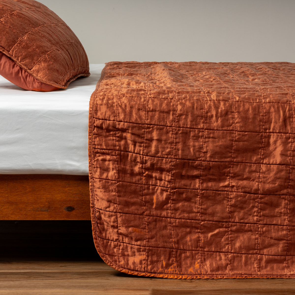 Foot-of-bed view of Bella Notte Sel coverlet in Autumn, showing quilted grid stitching on crinkled silk.