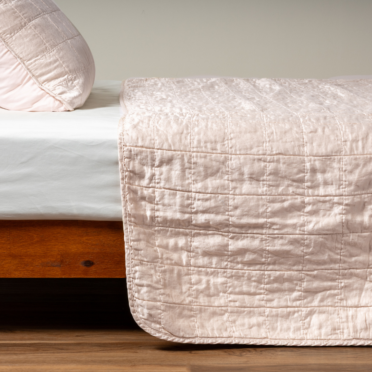 Pearl quilted Bella Notte Sel coverlet draped over bed foot, showing stitched texture detail.