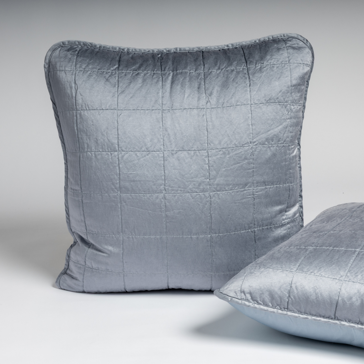 Tahoe Blue velvet sham with grid quilting, upright with second sham angled in foreground.