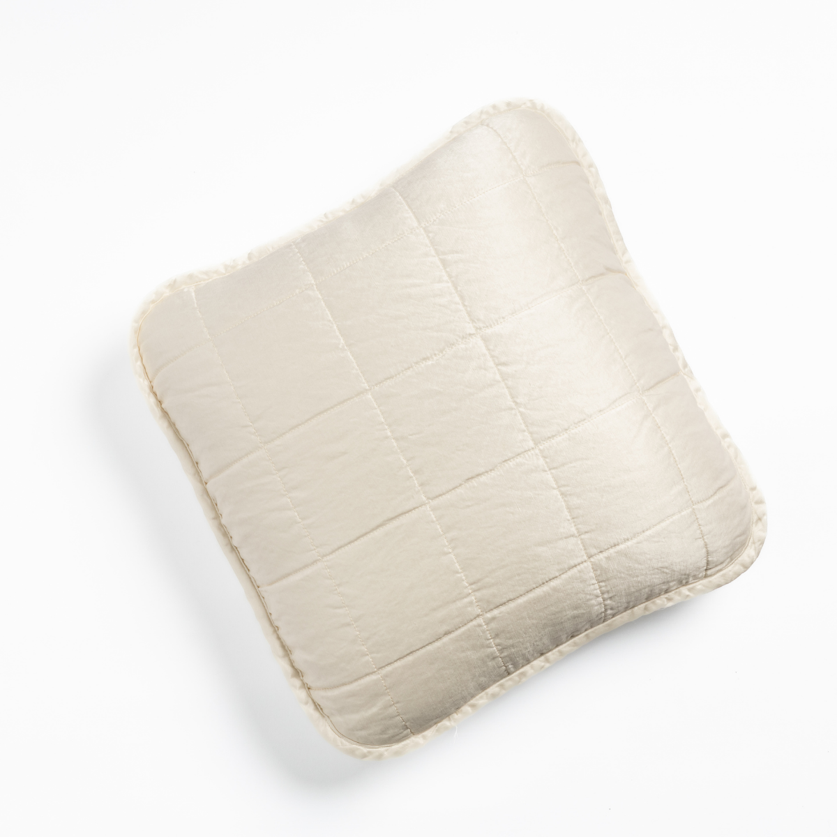 Winter White quilted throw pillow with frayed linen edges, overhead view.